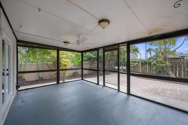 unfurnished sunroom featuring ceiling fan