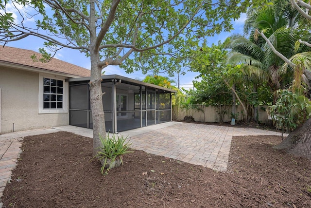 view of yard featuring a sunroom and a patio area