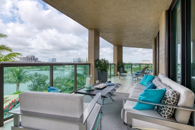 balcony with an outdoor living space and a water view