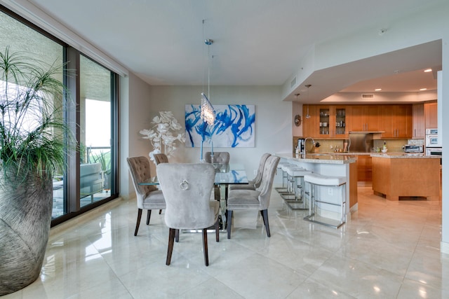 dining area featuring a wall of windows and sink