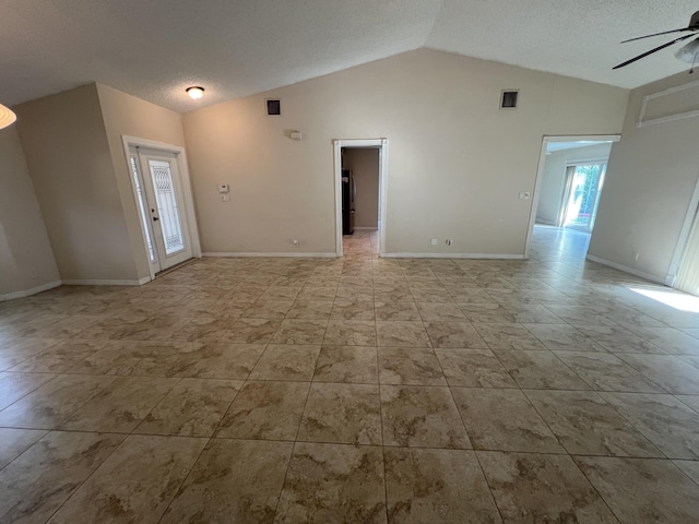 interior space featuring ceiling fan, lofted ceiling, and a textured ceiling