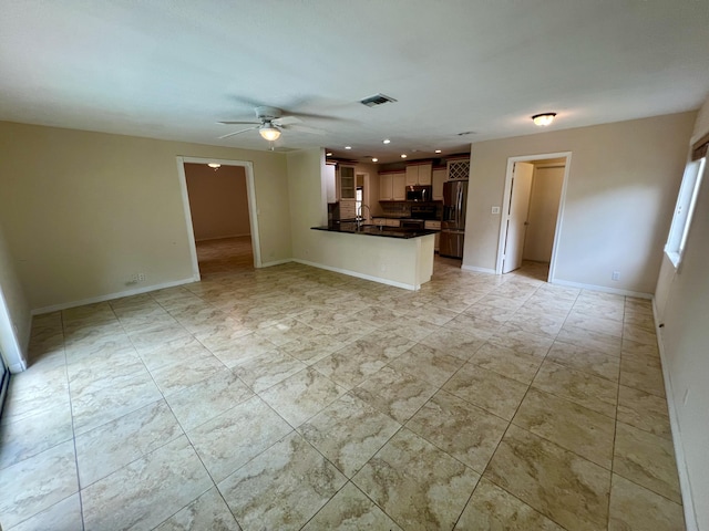 unfurnished living room with ceiling fan and sink