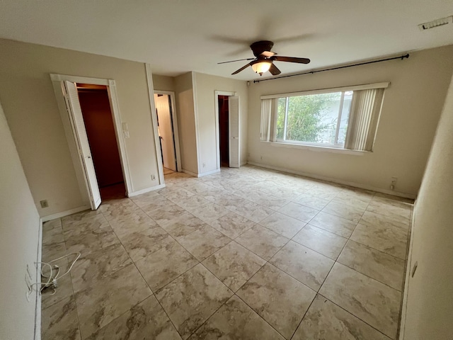 unfurnished bedroom with a walk in closet and ceiling fan