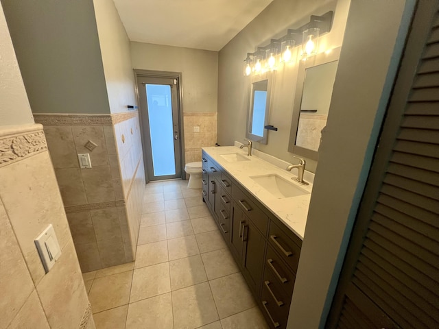 bathroom with tile patterned floors, vanity, tile walls, and toilet