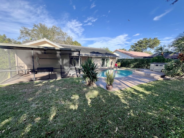 back of property featuring a lawn, a sunroom, and a patio