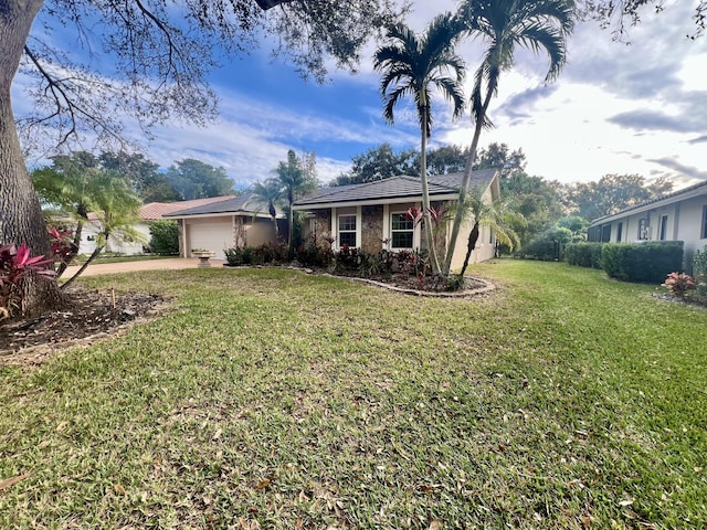 ranch-style house featuring a front lawn and a garage