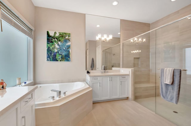 bathroom featuring shower with separate bathtub, vanity, an inviting chandelier, and plenty of natural light