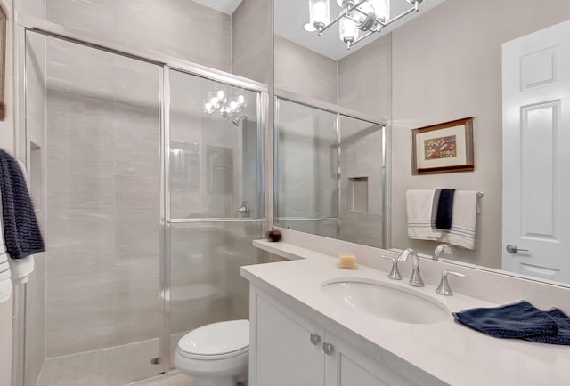 bathroom featuring vanity, toilet, and a shower with shower door