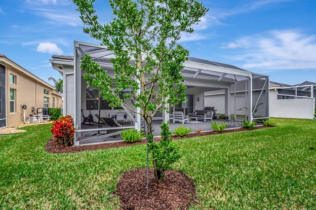 back of house with a yard, an outdoor living space, a patio area, and a lanai