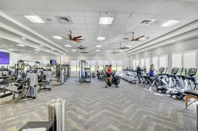 exercise room with ceiling fan and a drop ceiling