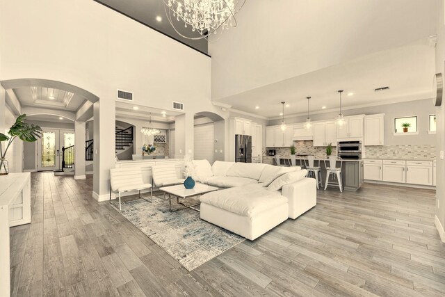 kitchen with white cabinetry, light stone counters, crown molding, appliances with stainless steel finishes, and custom exhaust hood