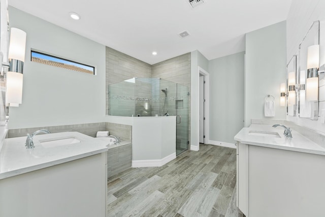 bathroom featuring hardwood / wood-style floors, vanity, and independent shower and bath