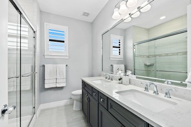 bathroom featuring a wealth of natural light, toilet, vanity, and walk in shower