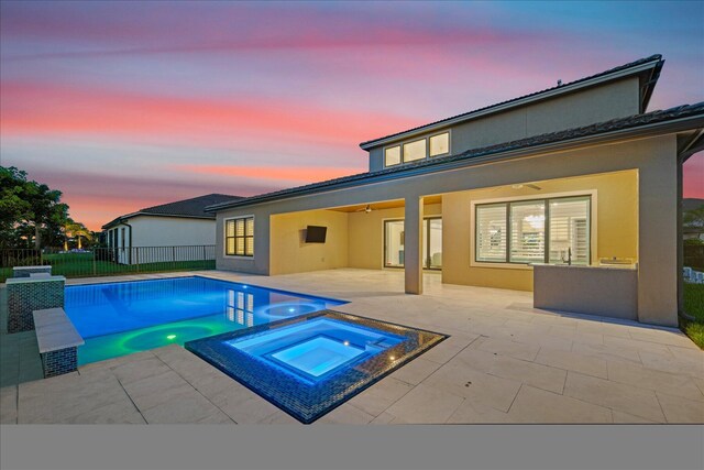 view of pool with an in ground hot tub, pool water feature, and a patio