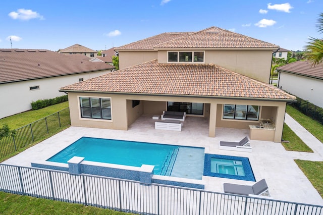 back of property featuring a patio area, an outdoor living space, exterior kitchen, and a pool with hot tub