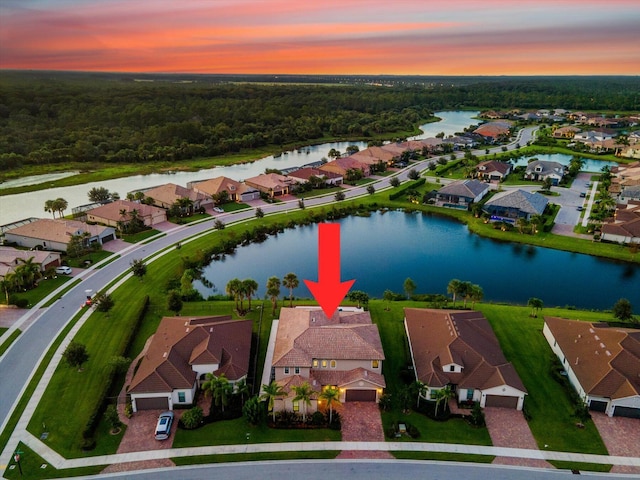 aerial view at dusk featuring a water view