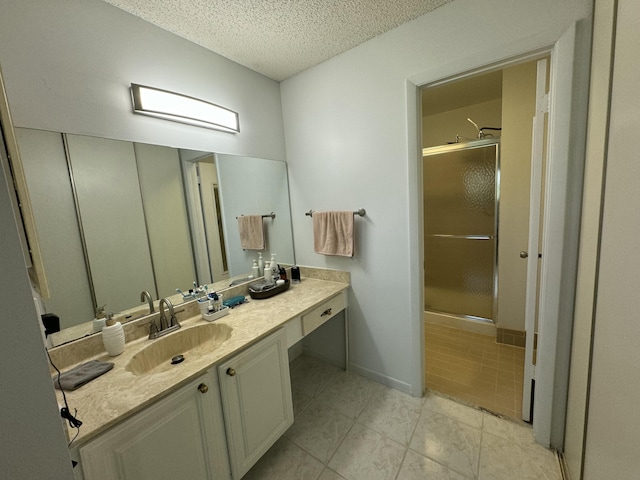 bathroom featuring vanity, a textured ceiling, and an enclosed shower