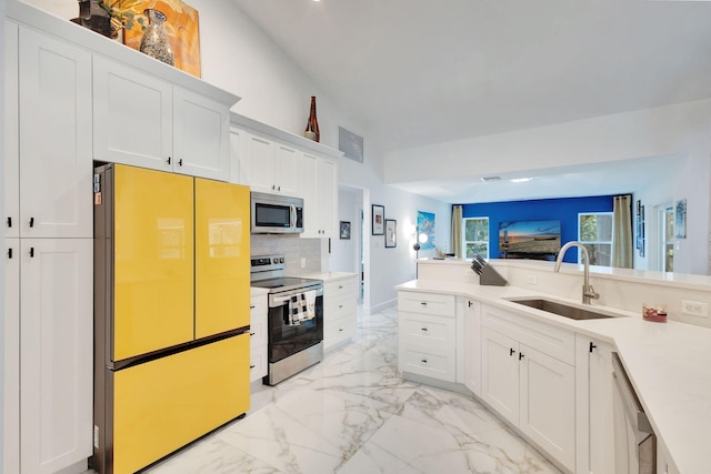 kitchen with sink, white cabinetry, stainless steel appliances, and tasteful backsplash