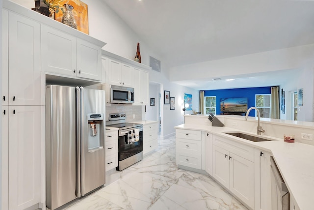 kitchen featuring decorative backsplash, white cabinetry, sink, and appliances with stainless steel finishes