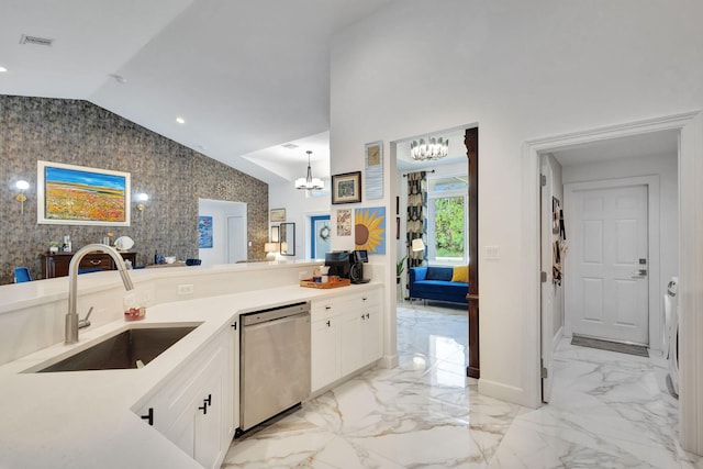 kitchen with stainless steel dishwasher, vaulted ceiling, sink, a notable chandelier, and white cabinetry