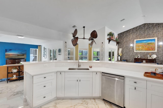 kitchen with white cabinets, dishwasher, lofted ceiling, and sink