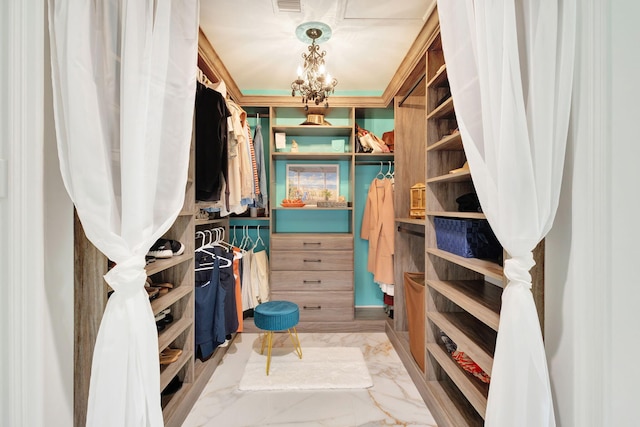 walk in closet with an inviting chandelier