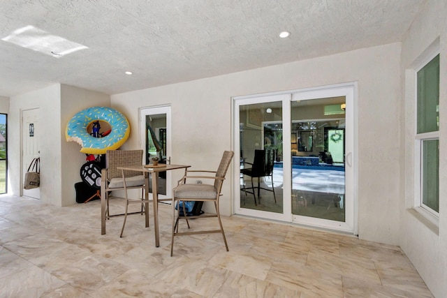 dining room featuring a healthy amount of sunlight and a textured ceiling