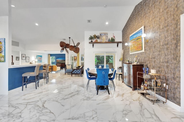 dining space featuring ceiling fan and a towering ceiling