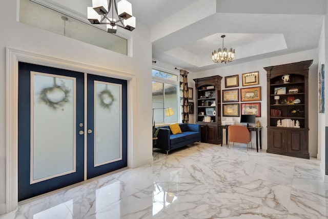 entryway with a chandelier and a tray ceiling