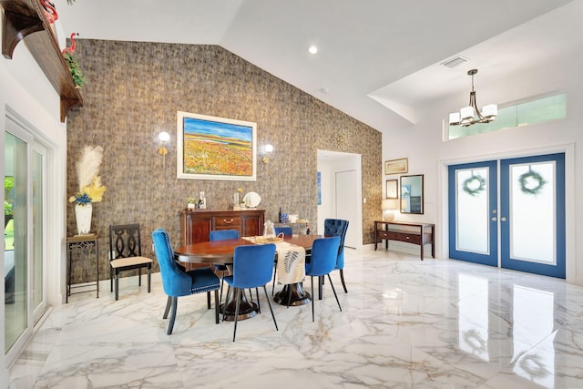 dining area with french doors, a high ceiling, and an inviting chandelier