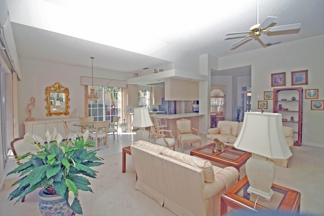 carpeted living room with a textured ceiling and ceiling fan with notable chandelier