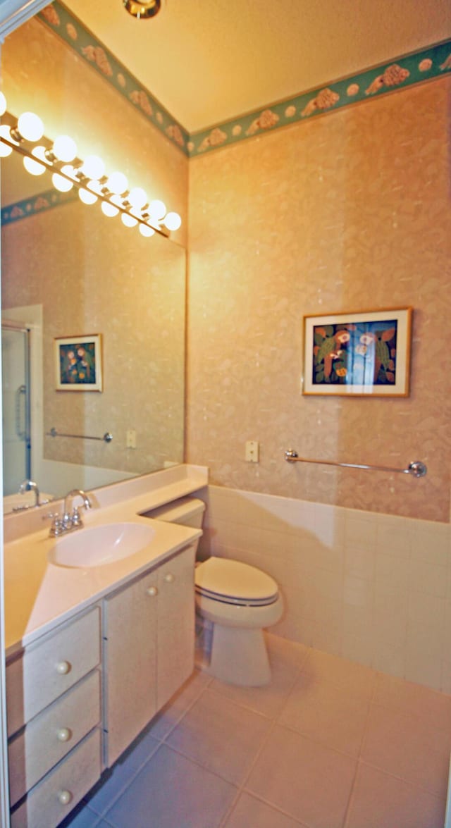 bathroom with tile patterned flooring, vanity, toilet, and a shower with shower door