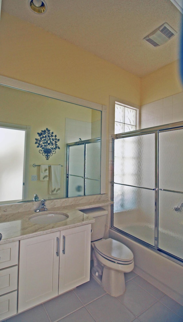 full bathroom with shower / bath combination with glass door, vanity, tile patterned floors, and toilet