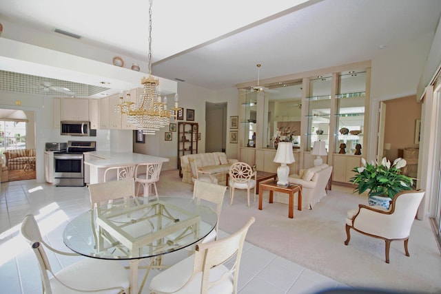 dining room with ceiling fan with notable chandelier and light colored carpet