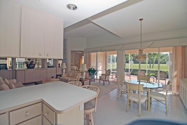 kitchen with kitchen peninsula, plenty of natural light, light tile patterned floors, and pendant lighting