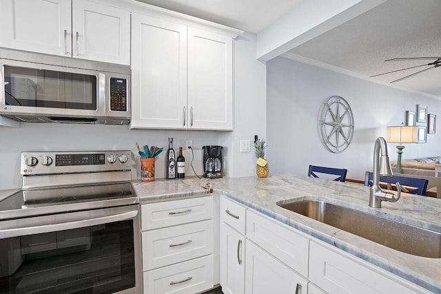 kitchen featuring sink, stainless steel appliances, kitchen peninsula, white cabinets, and ornamental molding