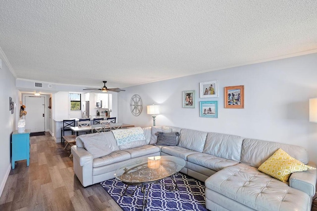 living room featuring hardwood / wood-style floors, a textured ceiling, and ceiling fan