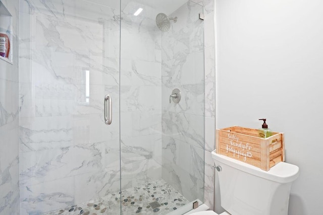 bathroom featuring an enclosed shower and toilet