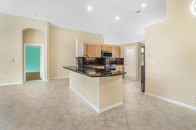 kitchen with light tile patterned flooring, appliances with stainless steel finishes, light brown cabinetry, sink, and kitchen peninsula