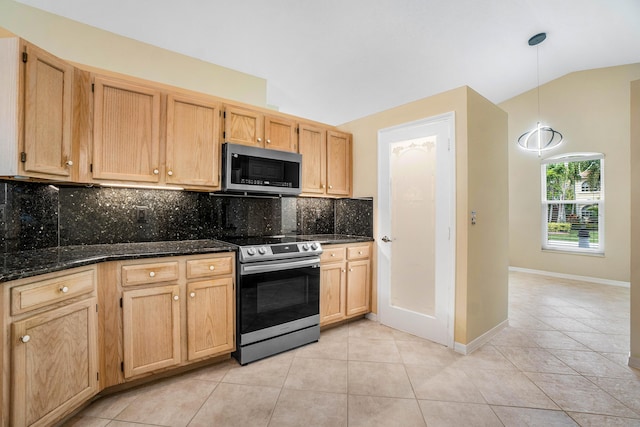 kitchen with appliances with stainless steel finishes, light tile patterned floors, lofted ceiling, and decorative backsplash