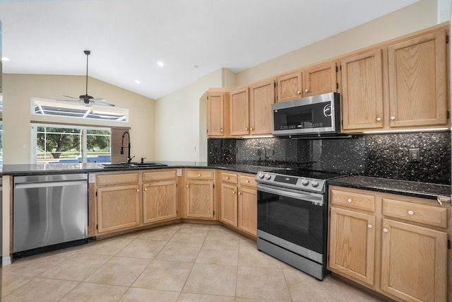 kitchen with sink, ceiling fan, appliances with stainless steel finishes, tasteful backsplash, and vaulted ceiling