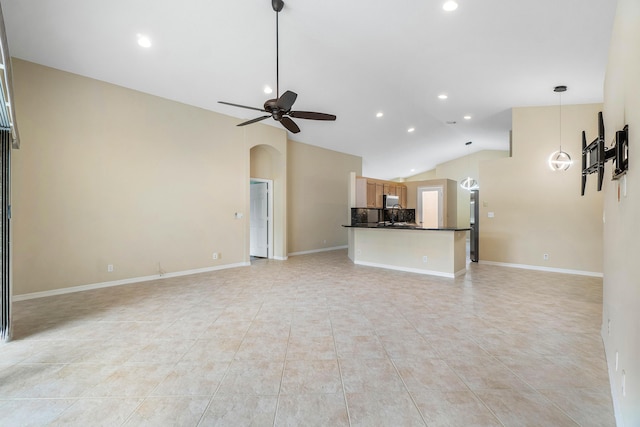 unfurnished living room featuring vaulted ceiling, light tile patterned flooring, and ceiling fan