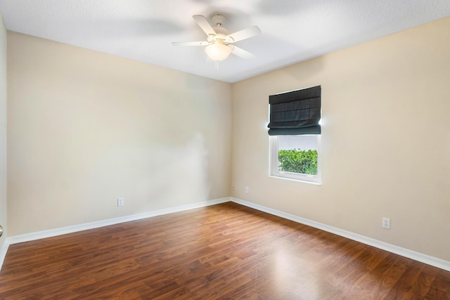 spare room featuring dark wood-type flooring and ceiling fan