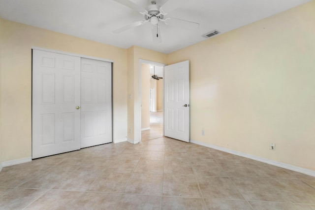 unfurnished bedroom with light tile patterned floors, a closet, and ceiling fan