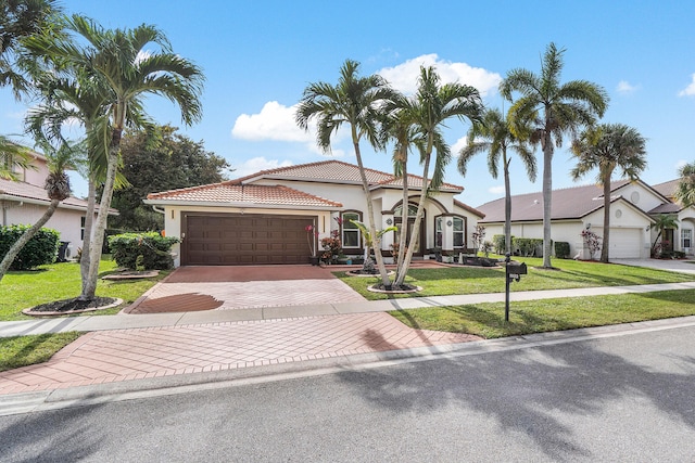 mediterranean / spanish-style house with a garage and a front lawn