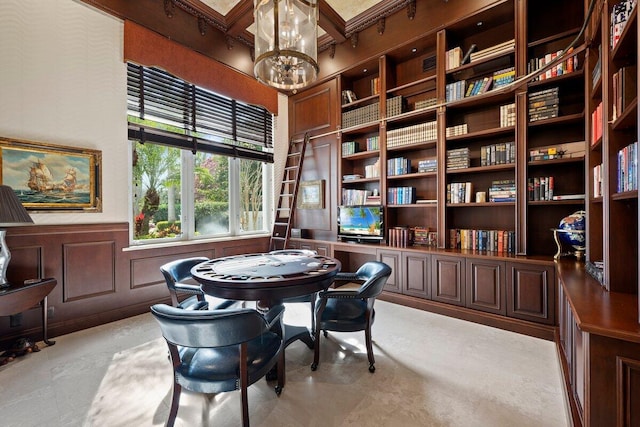 interior space with coffered ceiling, beamed ceiling, built in features, and a chandelier