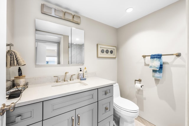 bathroom featuring vanity, toilet, and recessed lighting