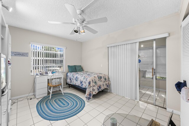 bedroom featuring ceiling fan, crown molding, light tile patterned floors, and a textured ceiling