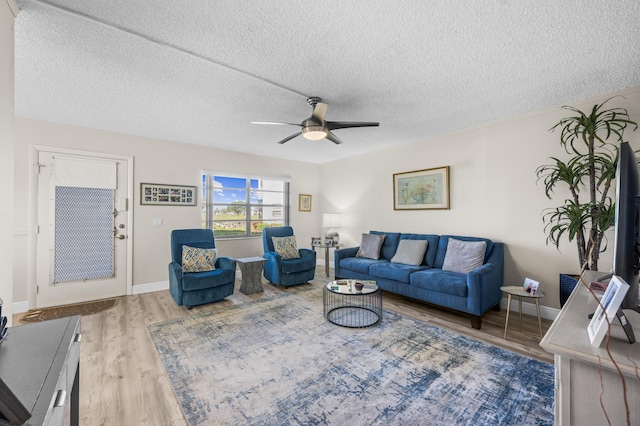 living room with ceiling fan, a textured ceiling, and hardwood / wood-style flooring