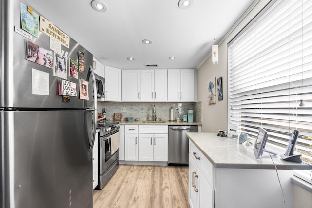 kitchen with white cabinets, sink, appliances with stainless steel finishes, and tasteful backsplash